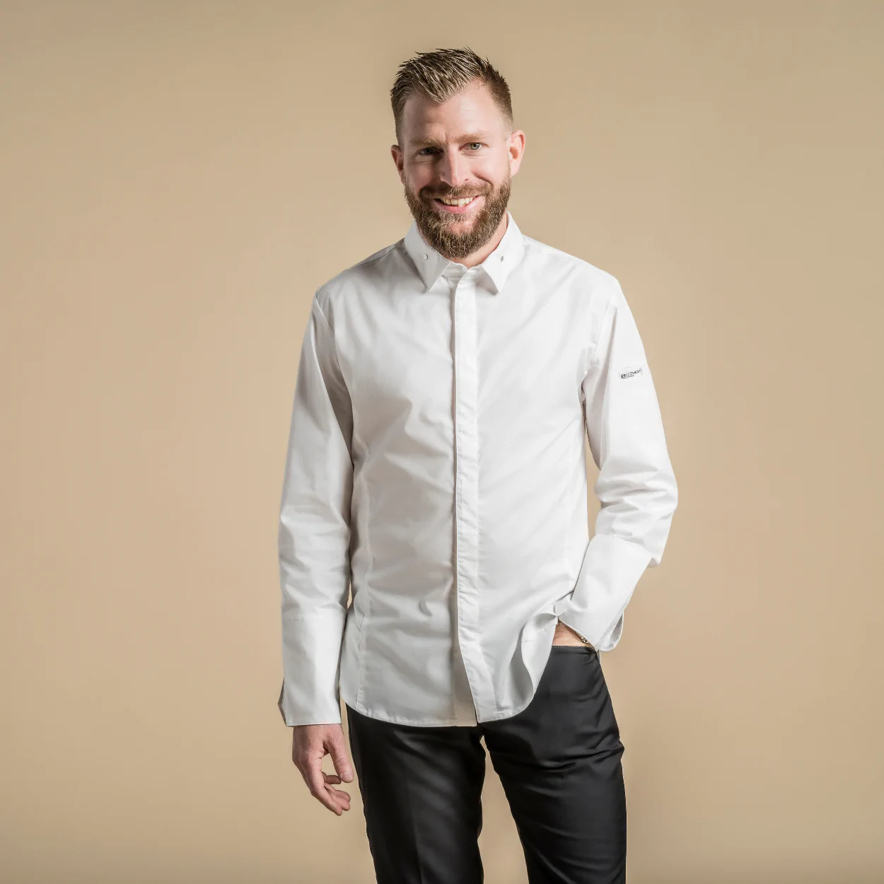 Unisex valkoinen kokkitakki, jossa teräksiset napit kauluksessa ja hihansuissa.