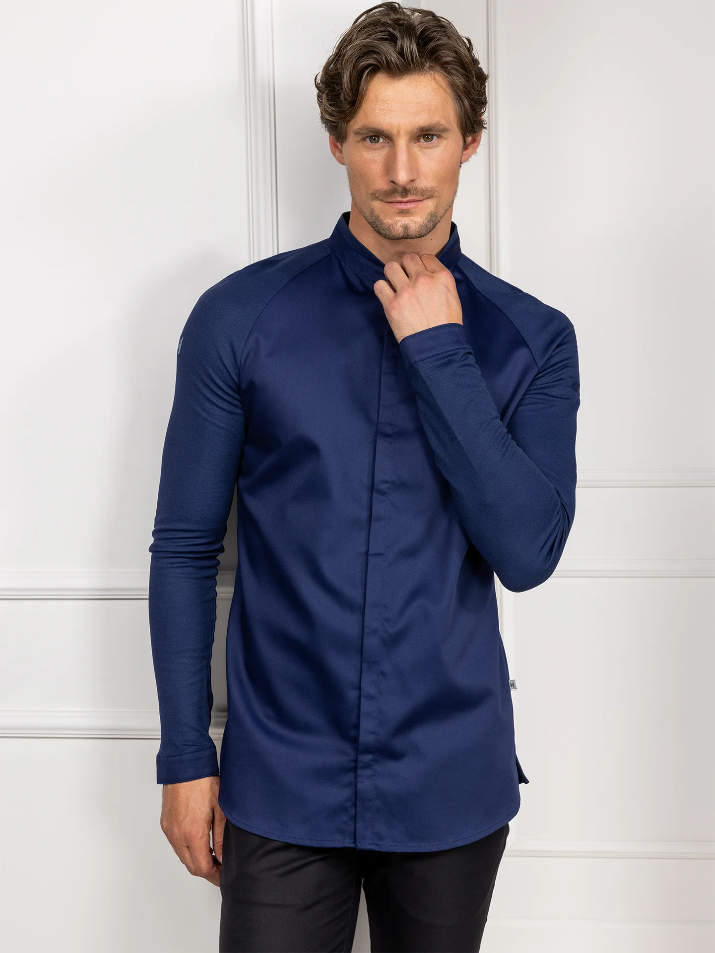 Unisex tummansininen kokinvaate slim fit mallissa, maokaulus, piilonapitus edessä ja tasku hihassa.